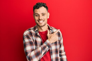 Young hispanic man wearing casual clothes smiling cheerful pointing with hand and finger up to the side