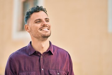 Obraz premium Young hispanic man smiling happy standing at the city.