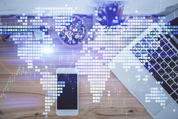 Obraz premium Double exposure of business theme hologram over desktop with phone. Top view. Mobile international trade connection concept.