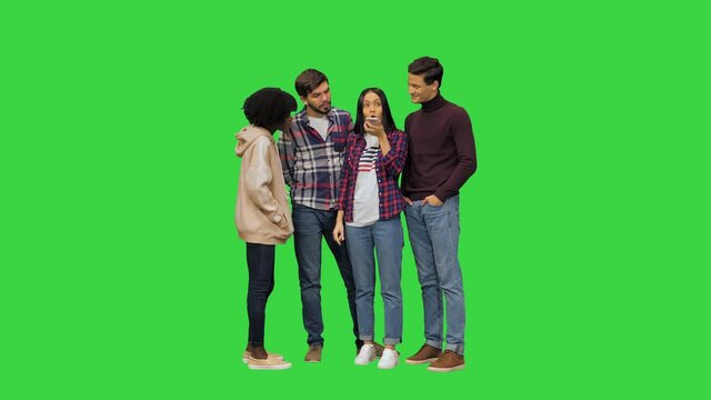 A young girl using her smartphones voice assistant to learn some information for her friends on a Green Screen, Chroma Key.