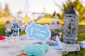 Yearling outdoor picnic party. One year old boy decorative elements photo zone. Props on sticks,...