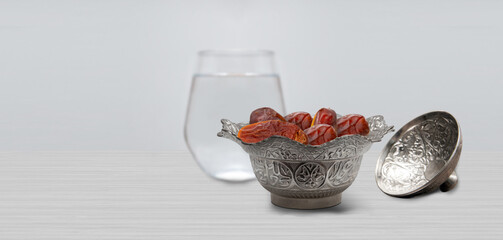 Typical of the month of Ramadan for muslims is the setting here, after the fast has been broken - water and pitted dates. Traditional iftar food.
metal bowl full of date fruits symbolizing Ramadan