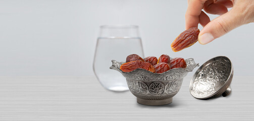 Typical of the month of Ramadan for muslims is the setting here, after the fast has been broken - water and pitted dates. Traditional iftar food.
metal bowl full of date fruits symbolizing Ramadan