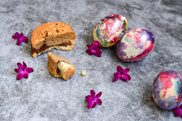 Colorful hand painted purple and rose  easter eggs, chocolat cookie e cake  and  spring blossom on wooden background