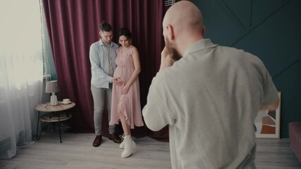 Guy touches tummy of pregnant woman posing for camera