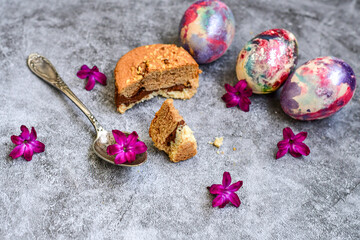 Colorful hand painted purple and rose  easter eggs, chocolat cookie e cake  and  spring blossom on wooden background