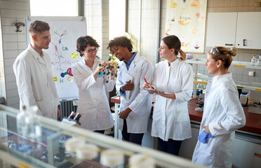 Team of young laboratory technicians discussing