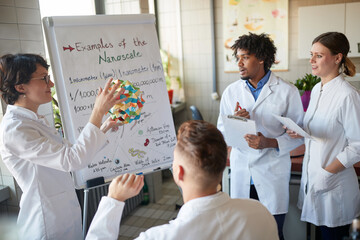 Obraz premium Young chemical students carefully listen to a lecture in the university laboratory. Science, chemistry, lab, people