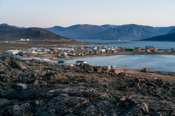 Dusk in a harsh arctic landscape with bare hills and ocean. Overlook of Inuit settlement of Qikiqtarjuaq, Broughton Island, Nunavut