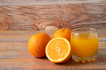 Oranges and a glass of juice isolated on wooden background