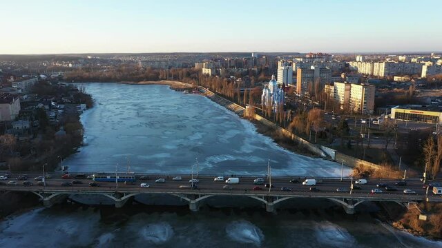 The Vinnytsia city traffic on the bridge at the winter aerial sunset view.