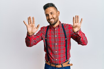 Handsome man with beard wearing hipster elegant look showing and pointing up with fingers number...