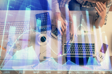 Double exposure of man and woman working together and financial graph hologram drawing. market...