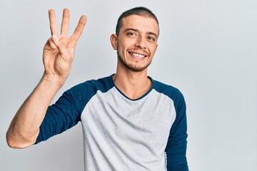 Fototapeta premium Hispanic young man wearing casual clothes showing and pointing up with fingers number three while smiling confident and happy.