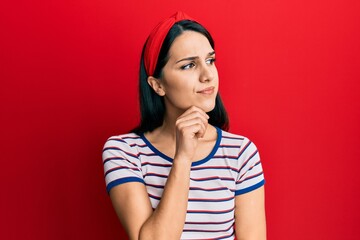 Fototapeta premium Young hispanic woman wearing casual clothes serious face thinking about question with hand on chin, thoughtful about confusing idea