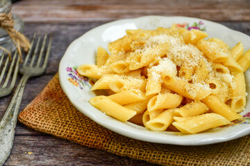  Home made  italian penne rigate pasta  with parmesan cheese,garlic  and black pepper .Pasta cacio e pepe. Mediterranean food concept