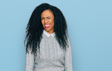 Middle age african american woman wearing casual clothes winking looking at the camera with sexy expression, cheerful and happy face.