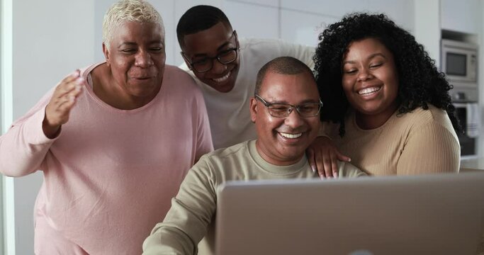 Happy african family having fun doing video call while using computer laptop at home