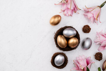 Fototapeta na wymiar Golden and silver Easter eggs in the nest with pink Double Lily flower.