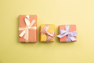 Pink and yellow gift boxes on yellow background. flat lay, top view, copy space