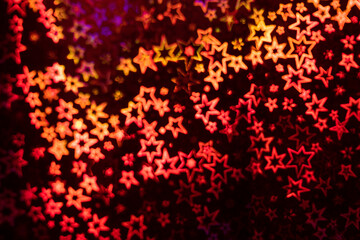 Red stars shimmer in different shades, starry bokeh, background