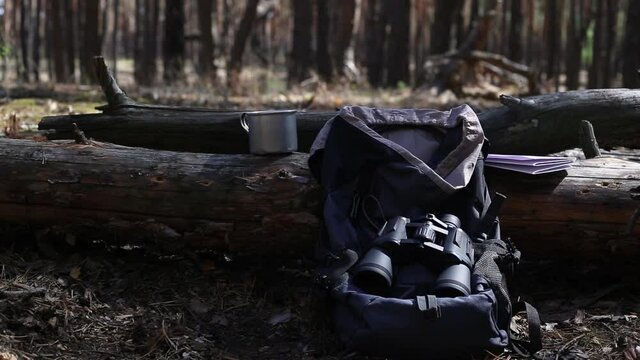 Tourist s backpack, binoculars, a map and equipment for a hike