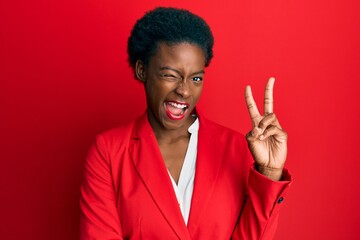 Young african american girl wearing business clothes smiling with happy face winking at the camera...