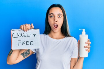 Young hispanic woman holding cruelty free cosmetics afraid and shocked with surprise and amazed...