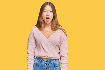 Fototapeta premium Beautiful blonde woman wearing casual winter pink sweater afraid and shocked with surprise and amazed expression, fear and excited face.