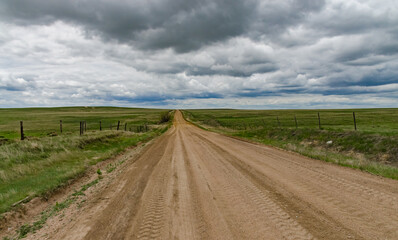 Fototapeta na wymiar Straight dirt road stretching into the distance in spring in Nebraska, US