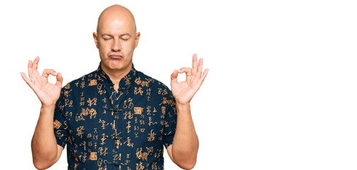 Naklejka premium Middle age bald man wearing casual clothes relax and smiling with eyes closed doing meditation gesture with fingers. yoga concept.