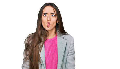 Young hispanic girl wearing business clothes making fish face with lips, crazy and comical gesture. funny expression.