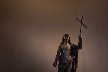Statue of Jesus holding a cross against a blank background