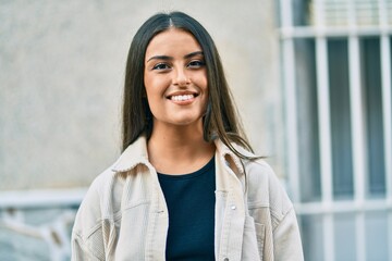 Young hispanic girl smiling happy standing at the city.