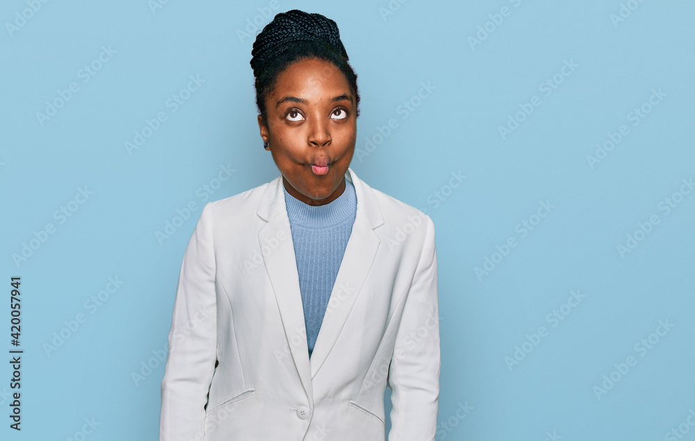 Sticker young african american woman wearing business clothes making fish face with lips, crazy and comical 