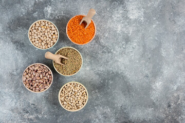 Assortment of raw dry legumes composition on marble surface