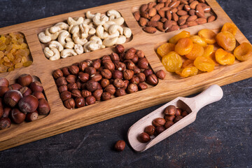 Dried fruits and nut mix on wooden board, top view. Healthy snack