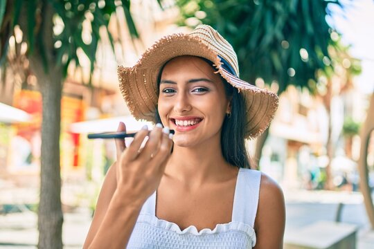 Young latin girl wearing summer style talking on the smartphone at street of city.
