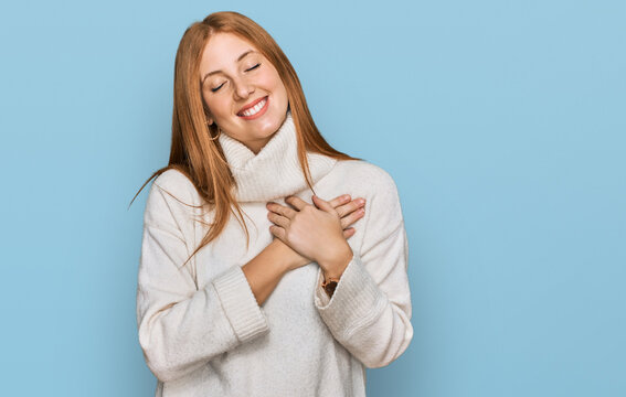 Young irish woman wearing casual winter sweater smiling with hands on chest with closed eyes and grateful gesture on face. health concept.