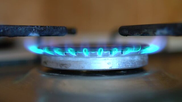 BluBlue flame propane gas ignition. Kitchen stove gas burner turn on. Slow motion macro close up of fire with blurred background. 