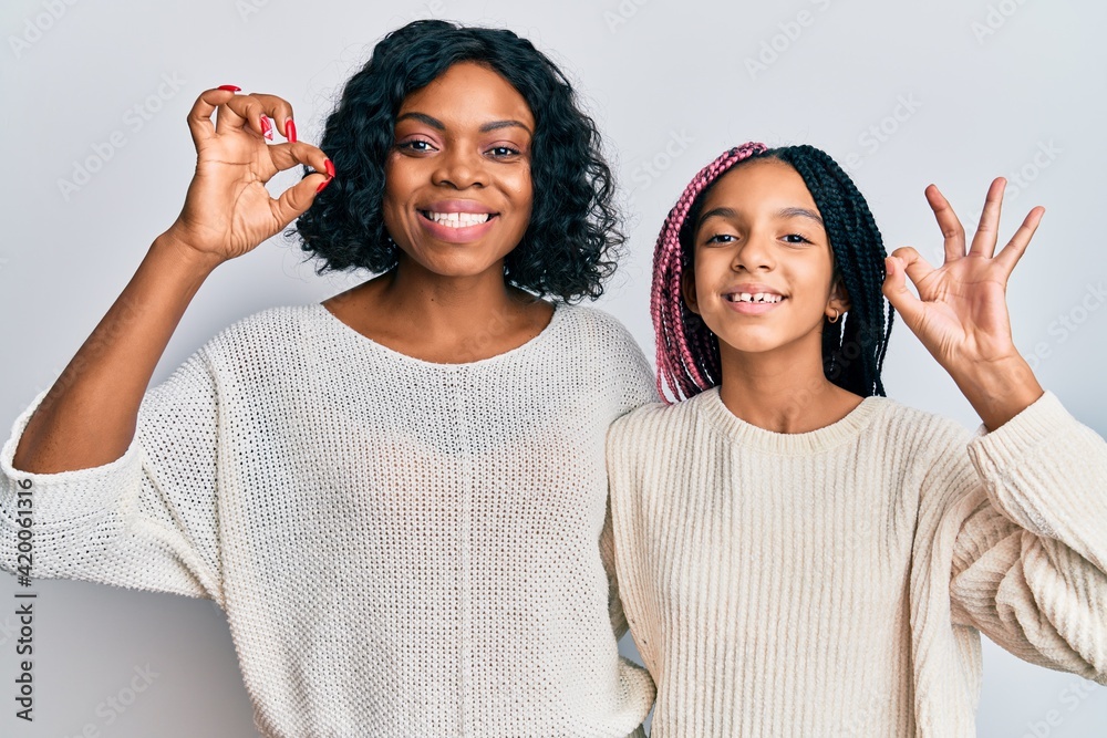 Poster beautiful african american mother and daughter wearing casual clothes and hugging smiling positive d