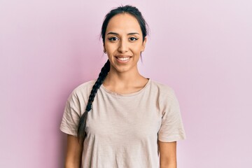 Fototapeta premium Young hispanic girl wearing casual white t shirt with a happy and cool smile on face. lucky person.