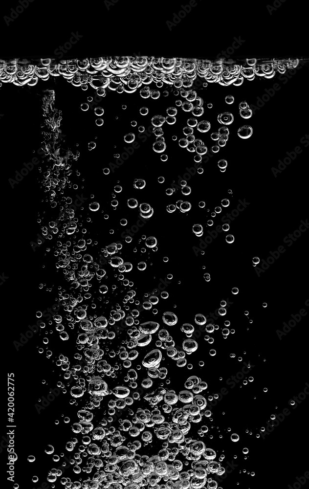 Wall mural Bubble soda and white oxygen air, in an underwater clear liquid with bubbles flowing up on the water surface, On a black background