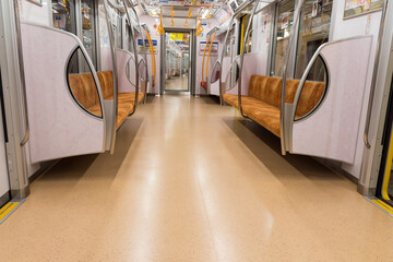 Subway car interior with colorful seats with no passengers in background. Empty tram interior. public transport train or metro in city