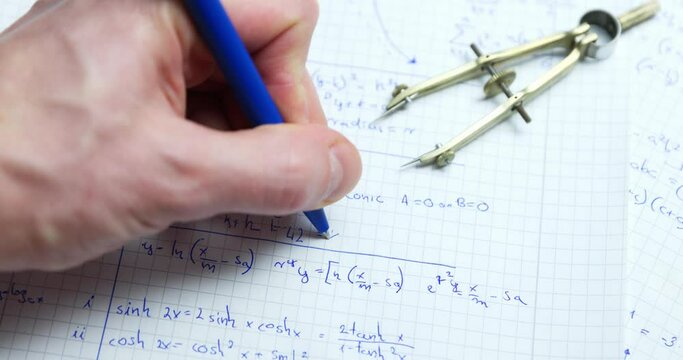 Man writing math exercise in notebook closeup