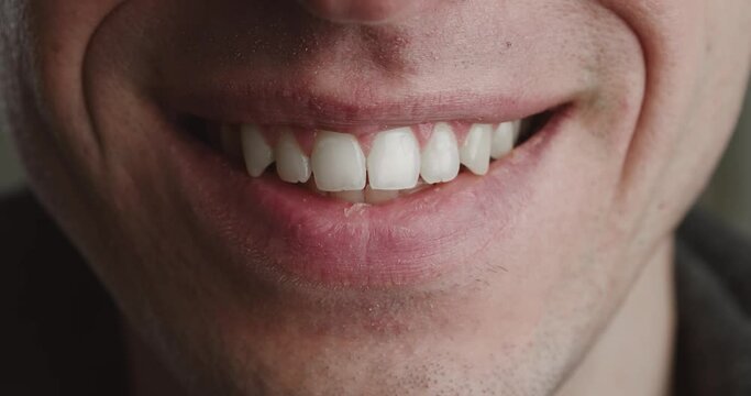 Close-up mouth of shocked young man is smiling, macro shot. Portrait of happy smile man.