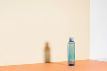 Blue cleansing lotion for the face. Layout of a liquid cosmetic product with hard shadows on the background. Copy space