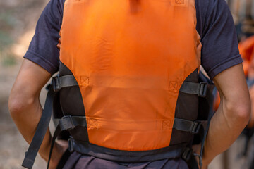 A man wearing an orange life jacket Rafting, water activities
