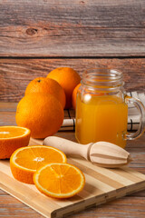Orange juice in a glass jar on the cutting board