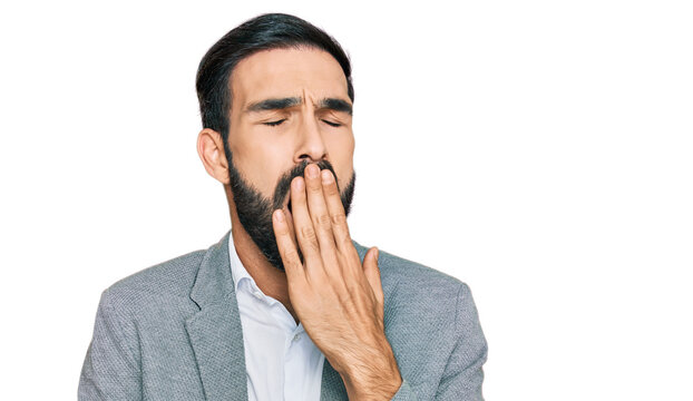 Young hispanic man wearing business clothes bored yawning tired covering mouth with hand. restless and sleepiness.